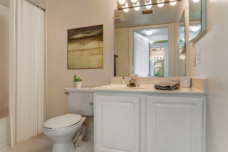 Classic Package I bathroom with white countertops, white cabinetry and tile flooring