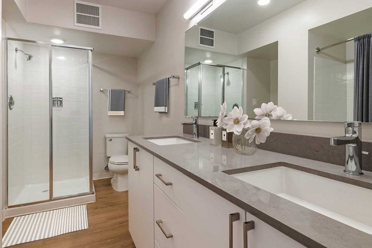 Limited availability: newly renovated Finish Package II apartment homes featuring baths with grey quartz countertops, white cabinetry, and hard surface flooring