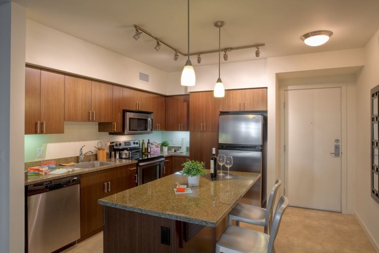 Classic Package I kitchen with brown speckled granite countertops, espresso cabinetry, stainless steel appliances, and hard surface flooring