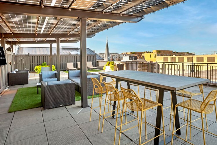 Rooftop terrace with dining area, lounge seating, and flatscreen TV