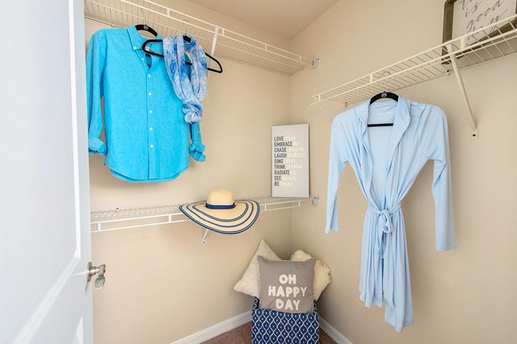 Spacious walk-in closet in the master bedrooms featuring built-in organizers.