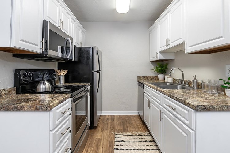 Your newly renovated kitchen in the Deluxe Chateau floor plan features upgraded white cabinetry and modern stainless steel appliances.