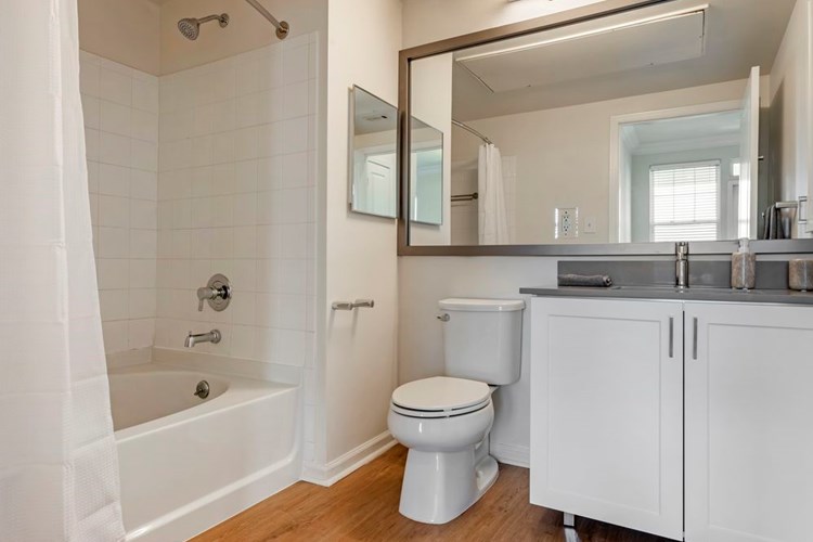 Newly renovated Finish Package II bath with white cabinetry, grey quartz countertops, and hard surface flooring