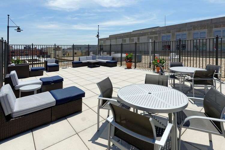 Rooftop lounge chairs and table seating area, facing towards E and 20th Streets