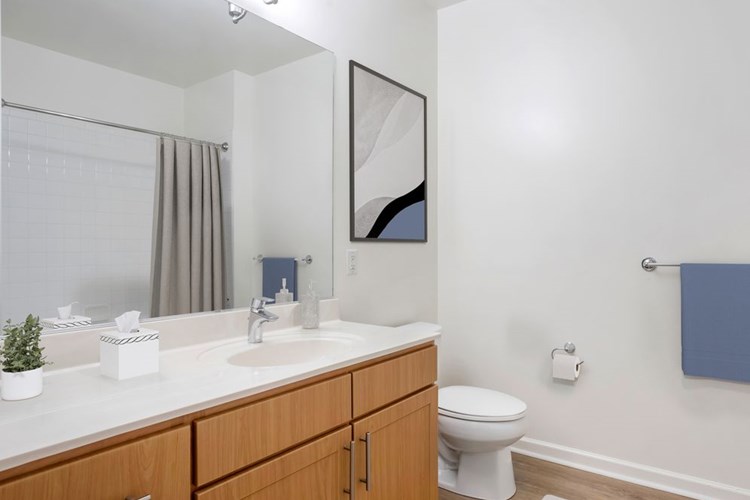 Classic Package bath with oak cabinetry, white quartz countertops, and hard surface flooring