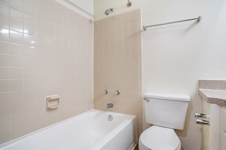 Renovated Package II bath with laminate countertops, white cabinetry, and hard surface flooring