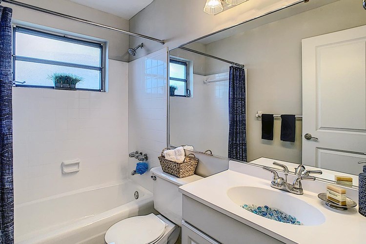 Bathrooms featuring updated countertops and cabinets and large mirrors.