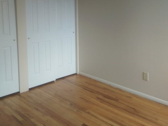 Bypass Closets doors and Hardwood flooring in Bed room