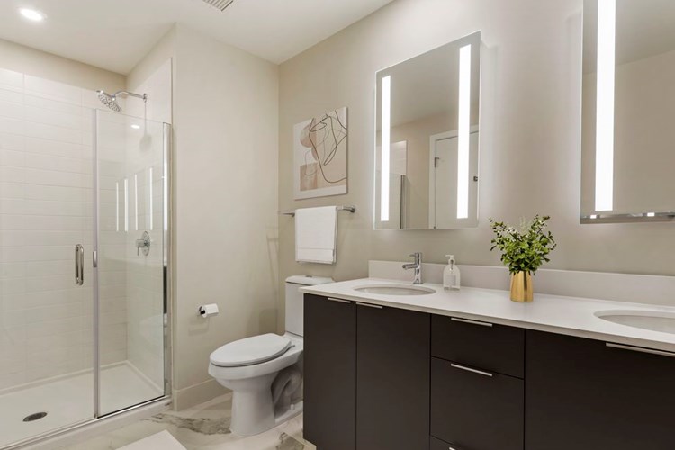 Renovated Package I bath with white quartz countertops, grey cabinetry, and hard surface flooring