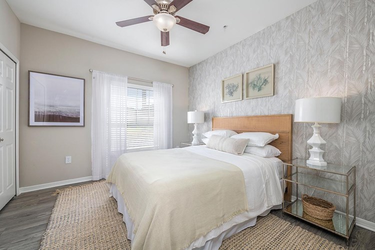 Our spacious bedrooms feature wood-style flooring and a ceiling fan. 