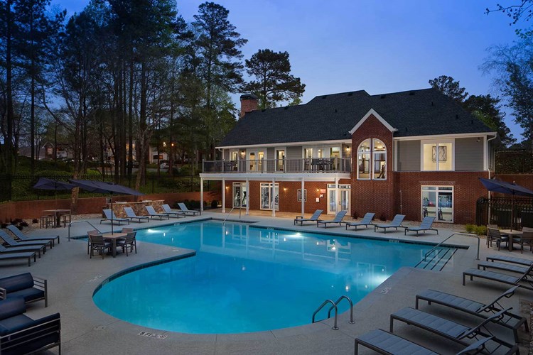 View of the clubhouse at twilight with the pool and sundeck