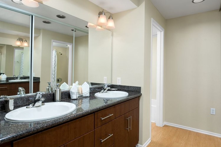 Classic Package I bath with chestnut cabinetry, grey speckled granite countertops, and hard surface flooring