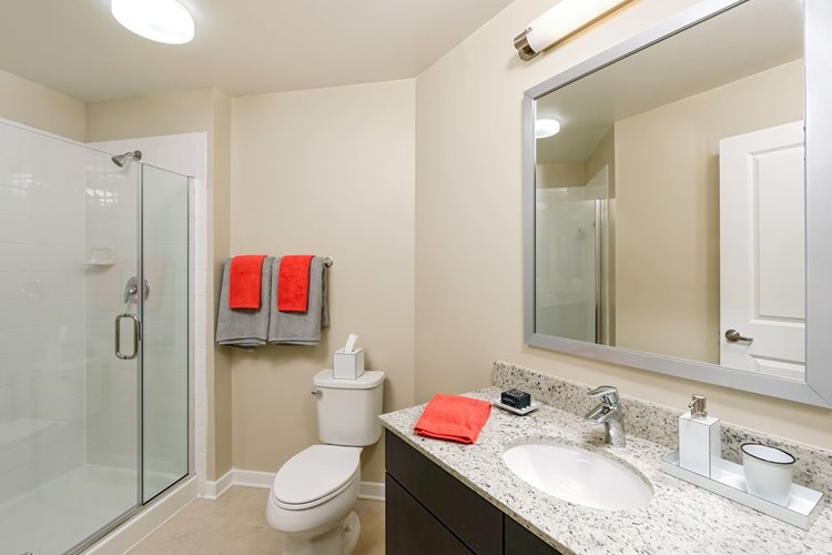 Bathroom with granite countertop, espresso cabinetry and tile flooring