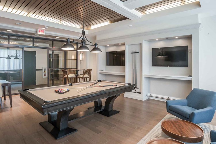 Game room with billiards table and large screen TVs accessible for gaming system set up