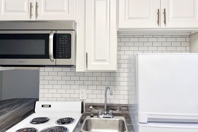 All apartments feature a white subway tile backsplash in the kitchen.
