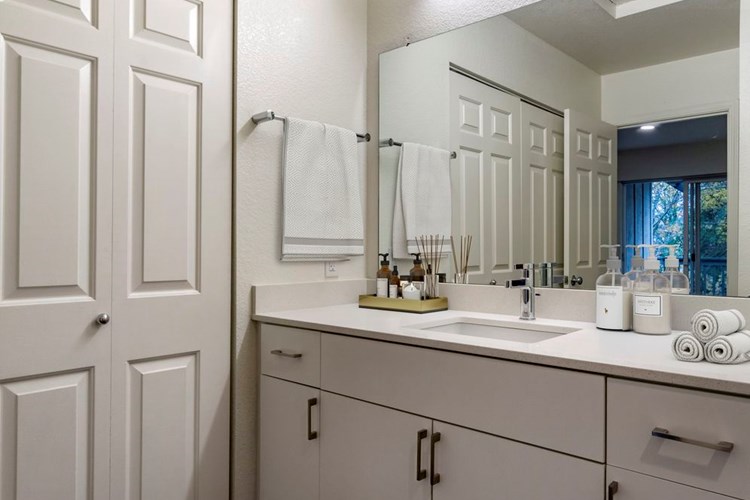 Renovated Package I bath with cream quartz countertops, white cabinetry, and hard surface flooring