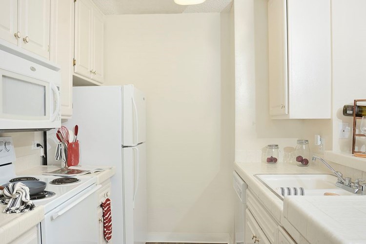 Classic Package I kitchen with white appliances, white tile countertops, white appliances, and vinyl tile flooring