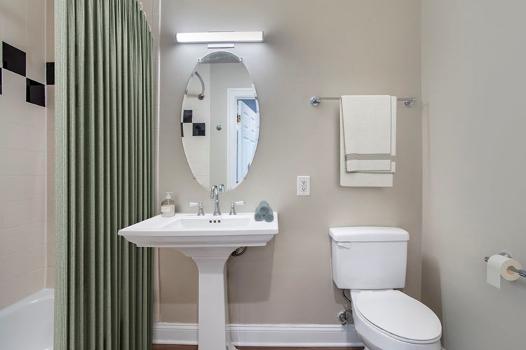 Renovated Package II bathroom with white countertops and hard surface flooring
