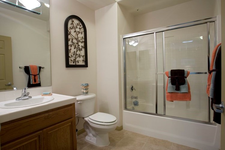 Classic Package I bath with white tile countertop, oak cabinetry, and tile flooring
