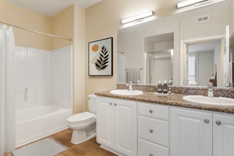 Renovated Package I bath with beige speckled granite countertop, white cabinetry, and hard surface flooring