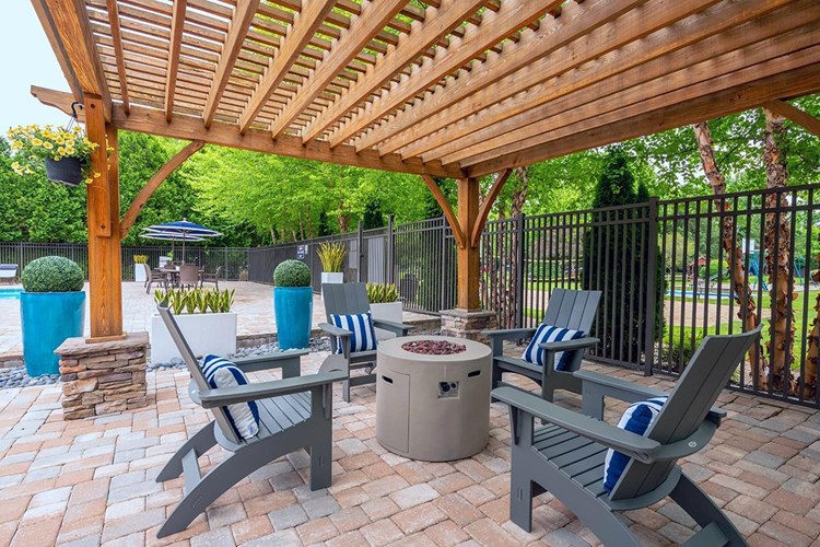 Warm up by our firepit under our poolside pergola.