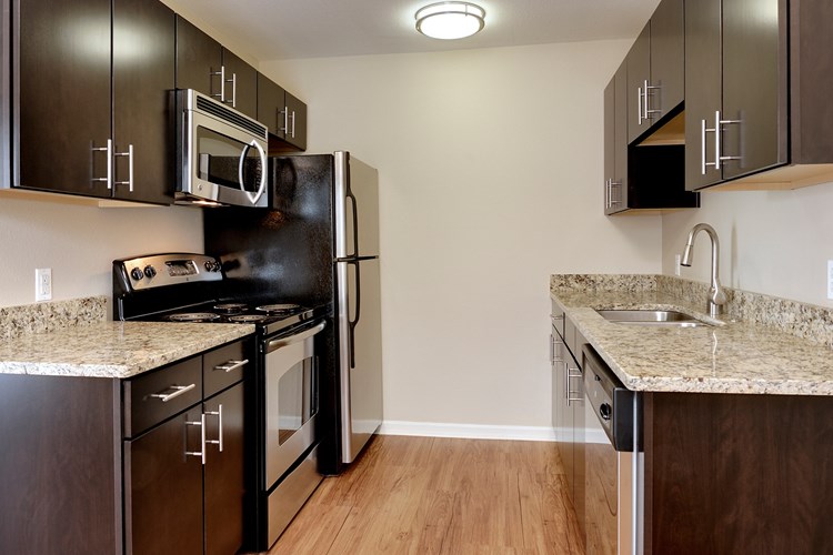 Kitchens offer stainless steel appliances and wood flooring