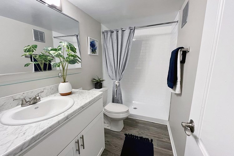 Other bathrooms feature a stand-up shower, wood-style flooring, and oversized mirrors. *In select units.