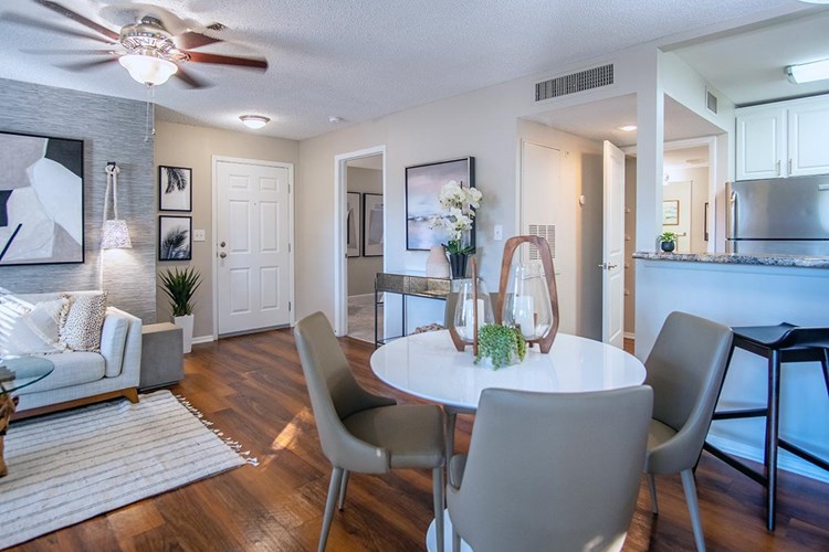 Our dining and living area features wood-style flooring and a ceiling fan.