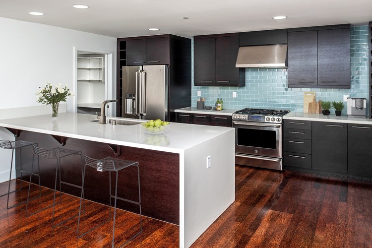 Designer kitchens with quartz countertops, stainless steel appliances and a breakfast bar