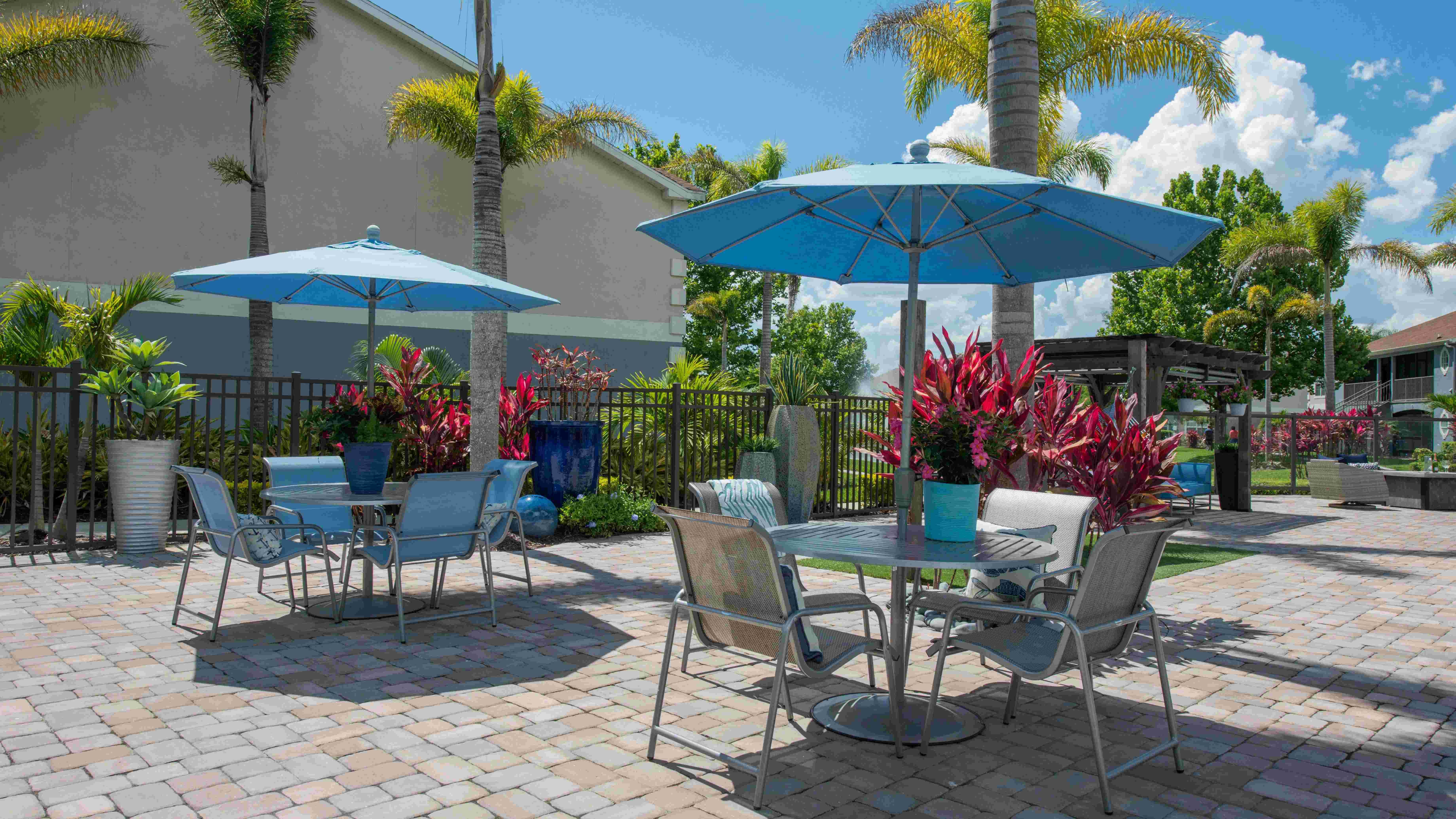 Our expansive sundeck features plenty of tables with umbrellas for residents to relax and dine poolside. 