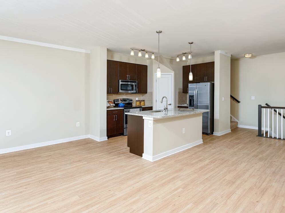 Classic Package II townhome kitchen and living room with hard surface flooring (select homes)