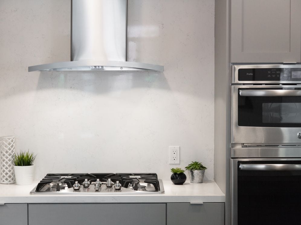 Signature Collection kitchen with light grey cabinetry, quartz stone countertop, stainless steel appliances and ceramic tile backsplash