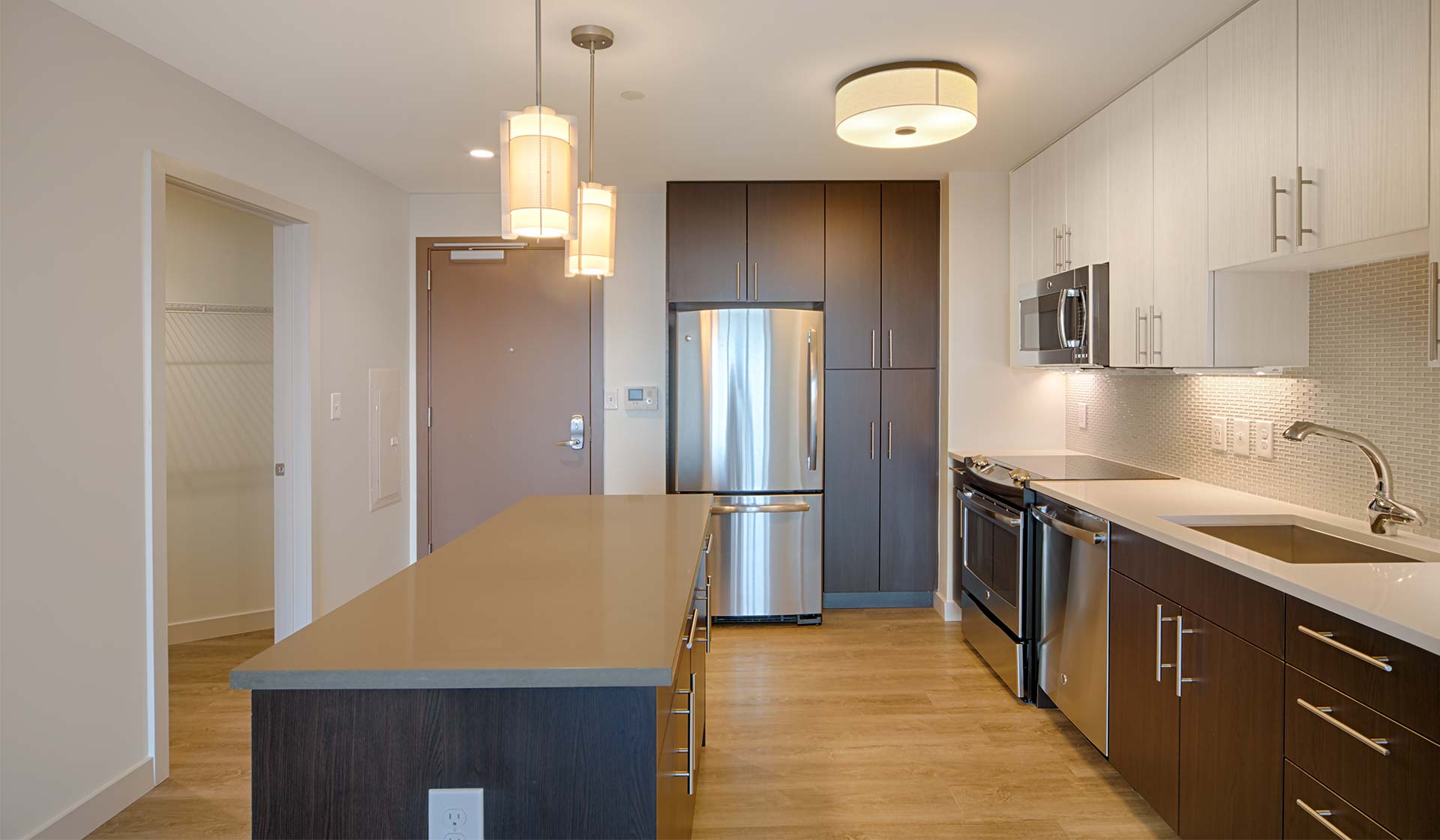 Brand-new kitchens feature stainless steel appliances, two-tone modern cabinets and quartz countertops