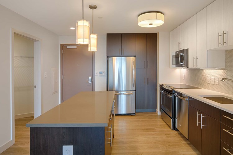 Brand-new kitchens feature stainless steel appliances, two-tone modern cabinets and quartz countertops