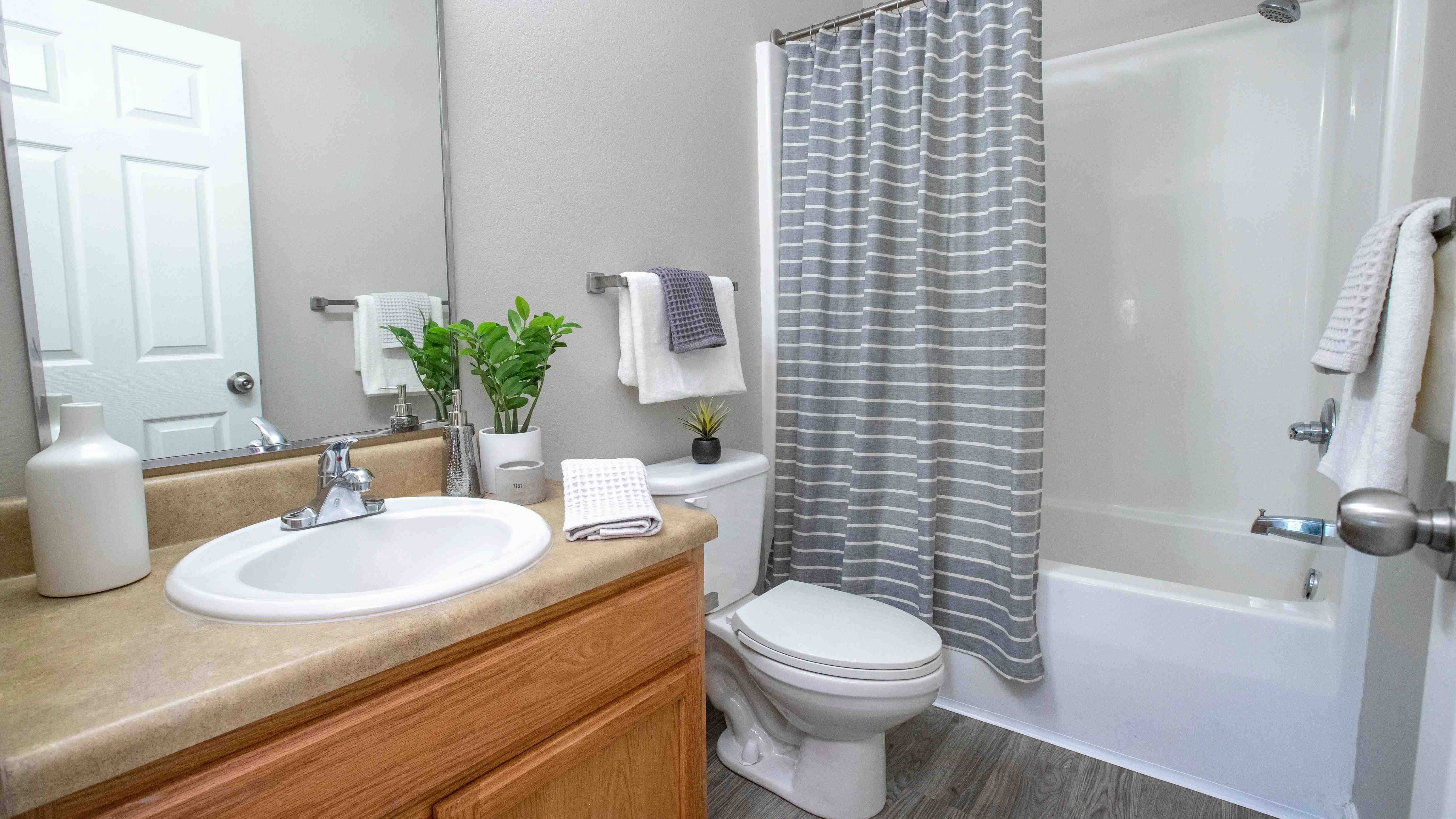 Experience the stylish allure of the guest bathroom, adorned with gracious mirrors, sleek chrome fixtures, and abundant counter space for your convenience.