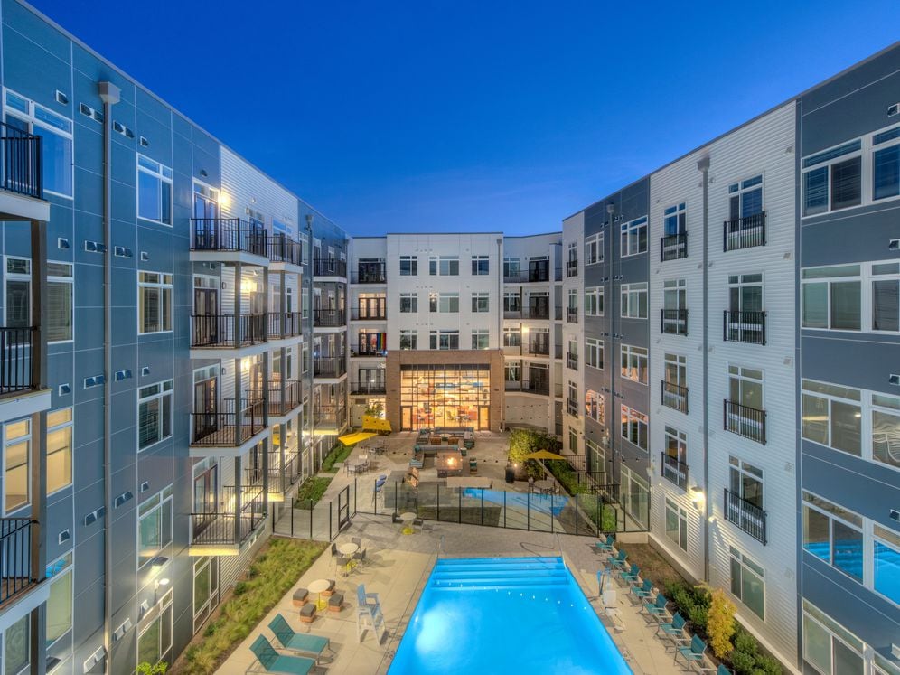 Building exteriors and courtyard with swimming pool, sundeck and lounge seating