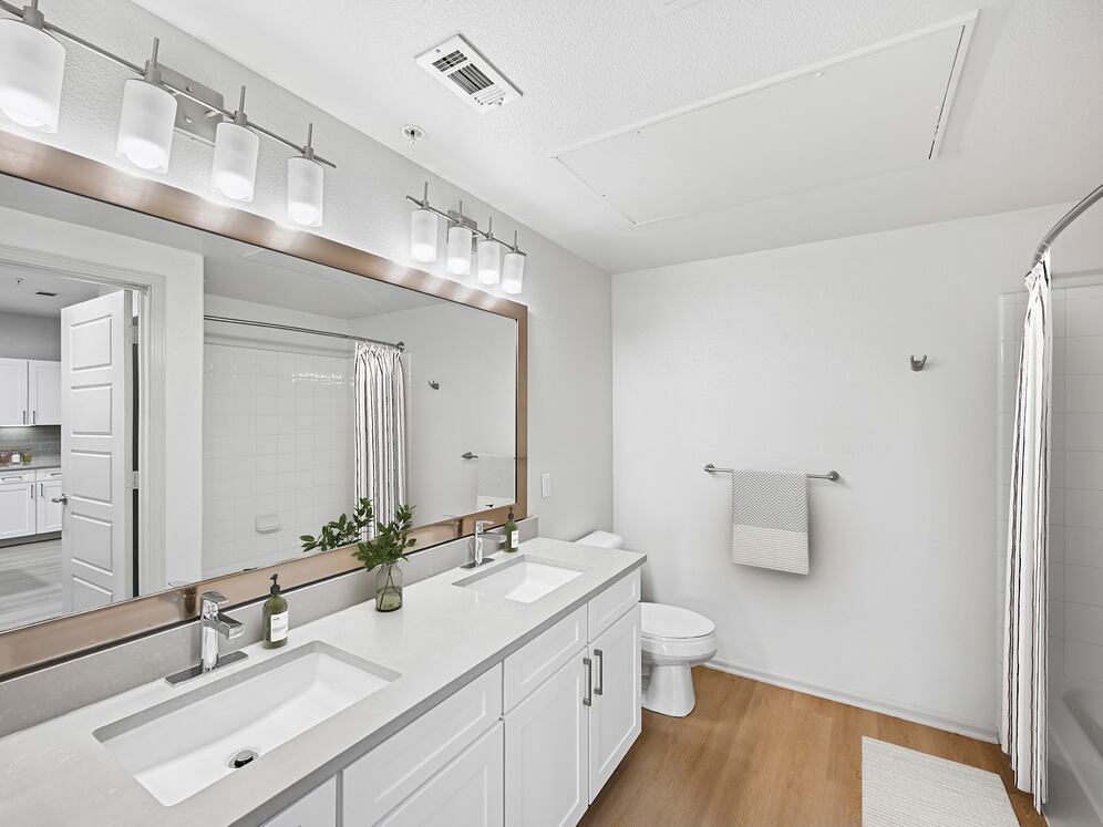 Renovated Package I bath with white cabinetry, grey quartz countertops, and hard surface flooring