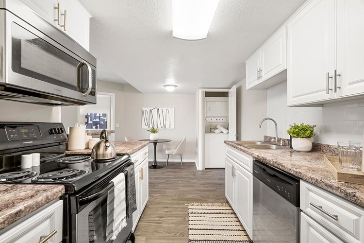 Newly renovated, galley style kitchens featuring stainless steel appliances.