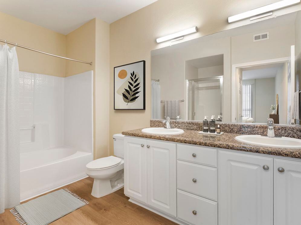 Renovated Package I bath with beige speckled granite countertop, white cabinetry, and hard surface flooring