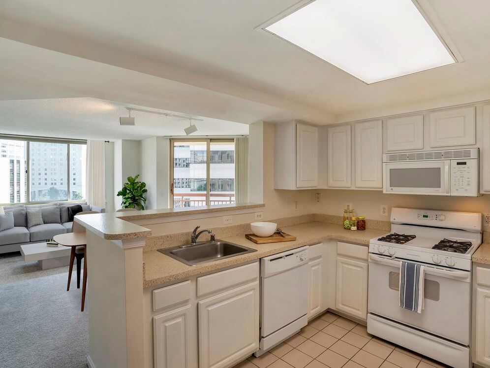 Classic Package I kitchen and living areas with white cabinetry, beige laminate countertops, white appliances, and tile flooring