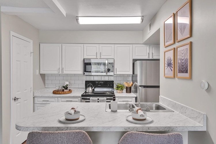 Newly renovated kitchens with wood-style flooring, white carrera counter tops, and stainless steel appliances.