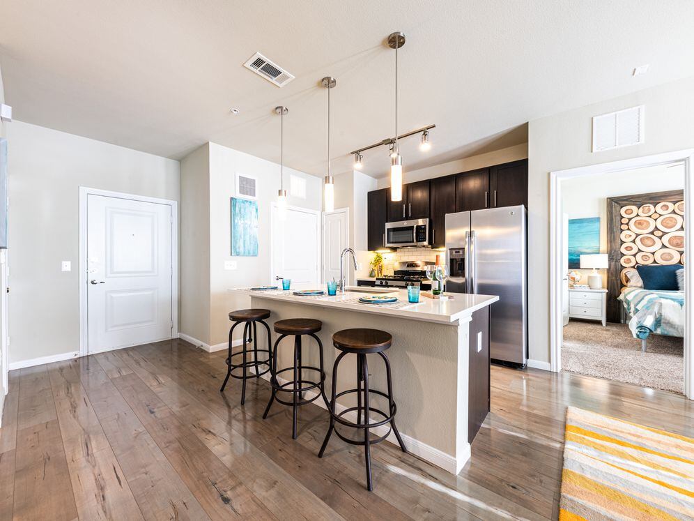 Kitchens with dark cabinetry, white quartz countertops, white subway tile backsplash, stainless steel appliances and hard surface flooring
