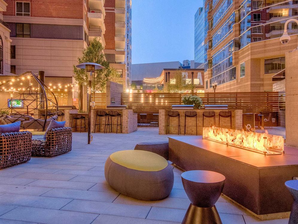 Outdoor chill space with fireplace, lounge seating, barbecue grills and dining area