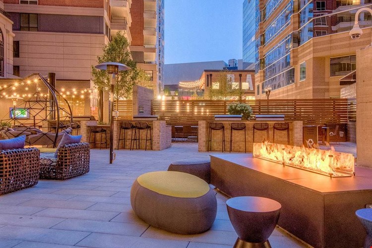 Outdoor chill space with fireplace, lounge seating, barbecue grills and dining area