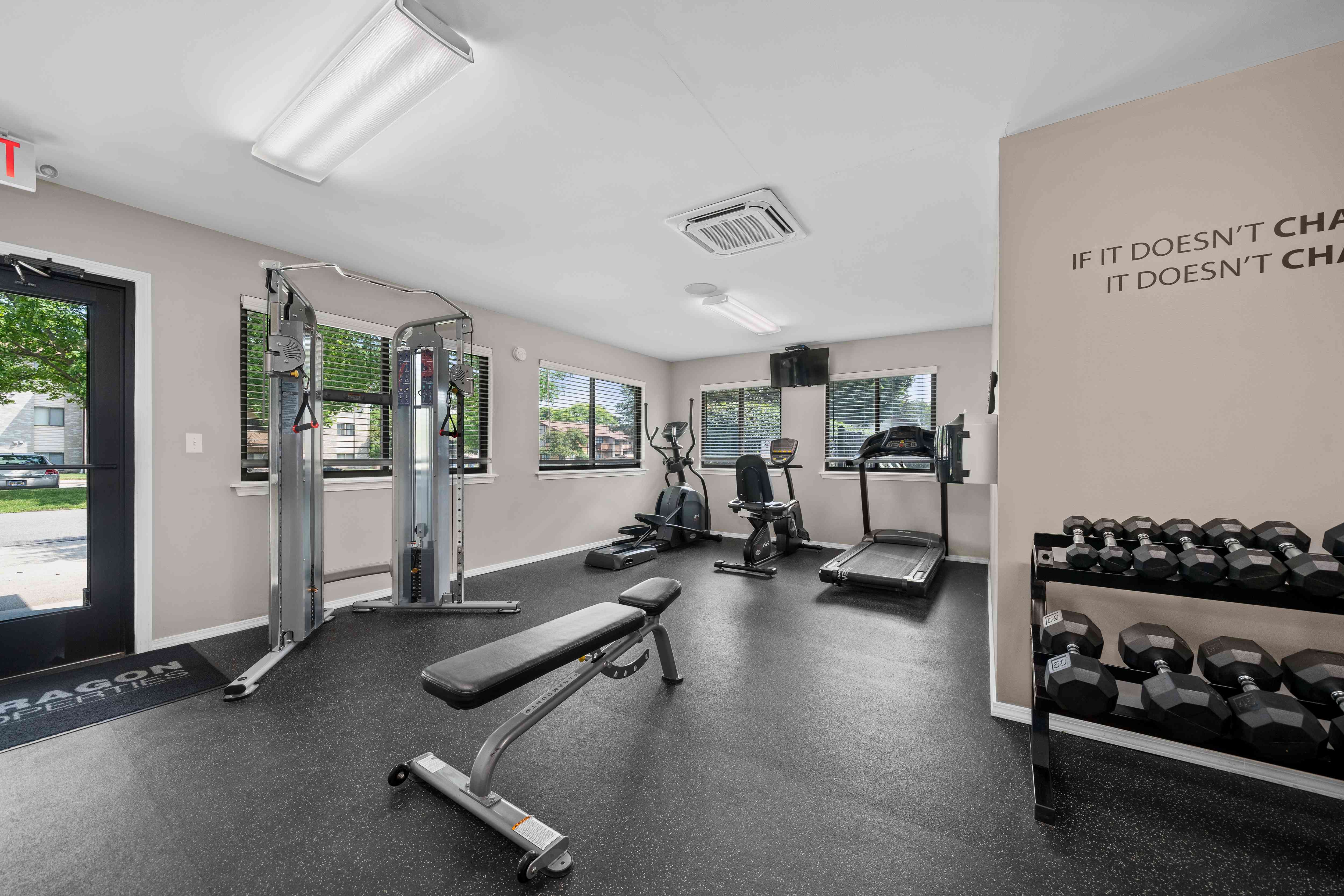 24-hour fitness center at cardio machines and weights at Woodland Villa Apartments in Westland, MI.