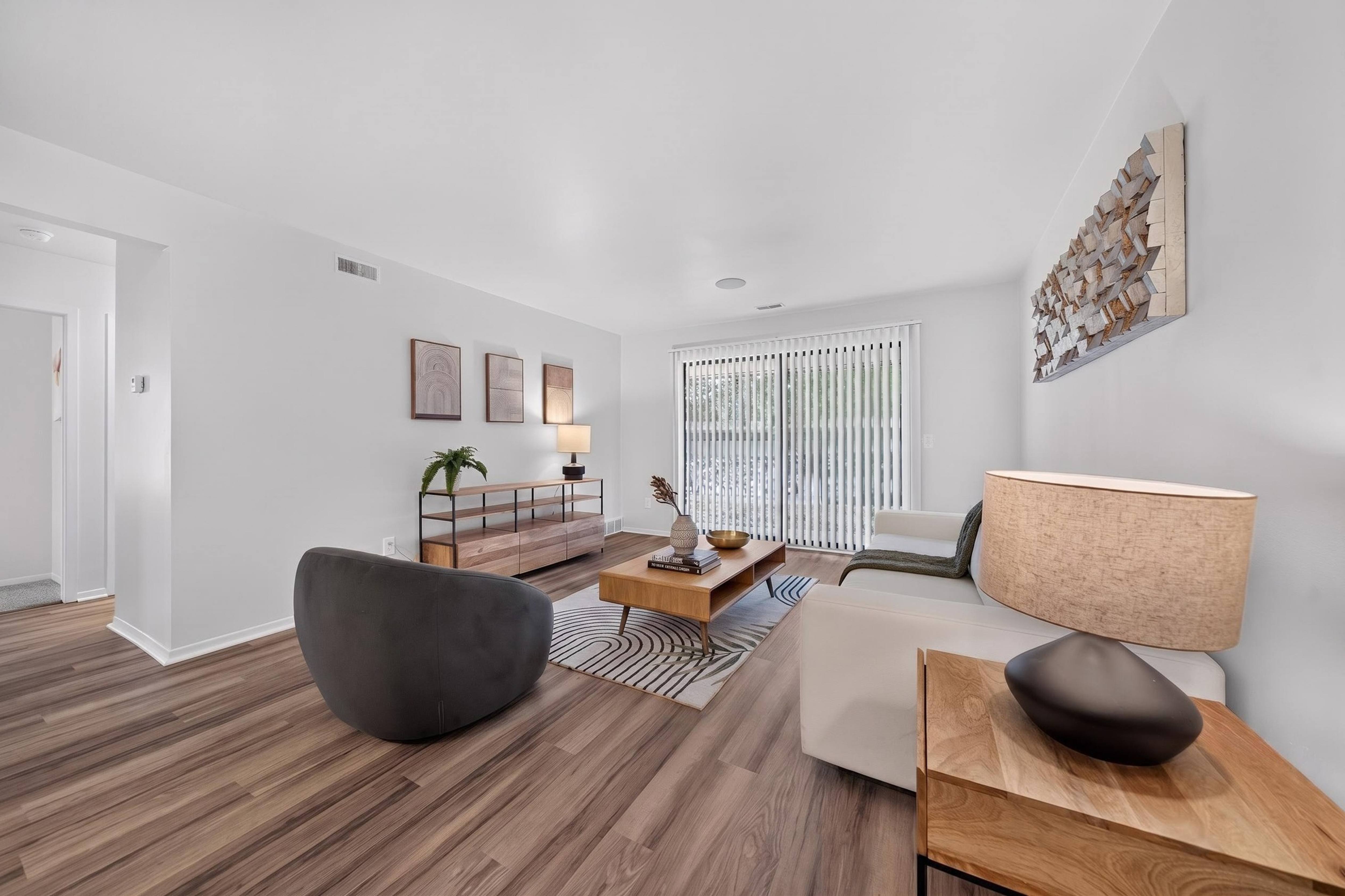 Spacious Living Room with Sliding Glass Door at Lakeside Village Apartments Clinton Township MI