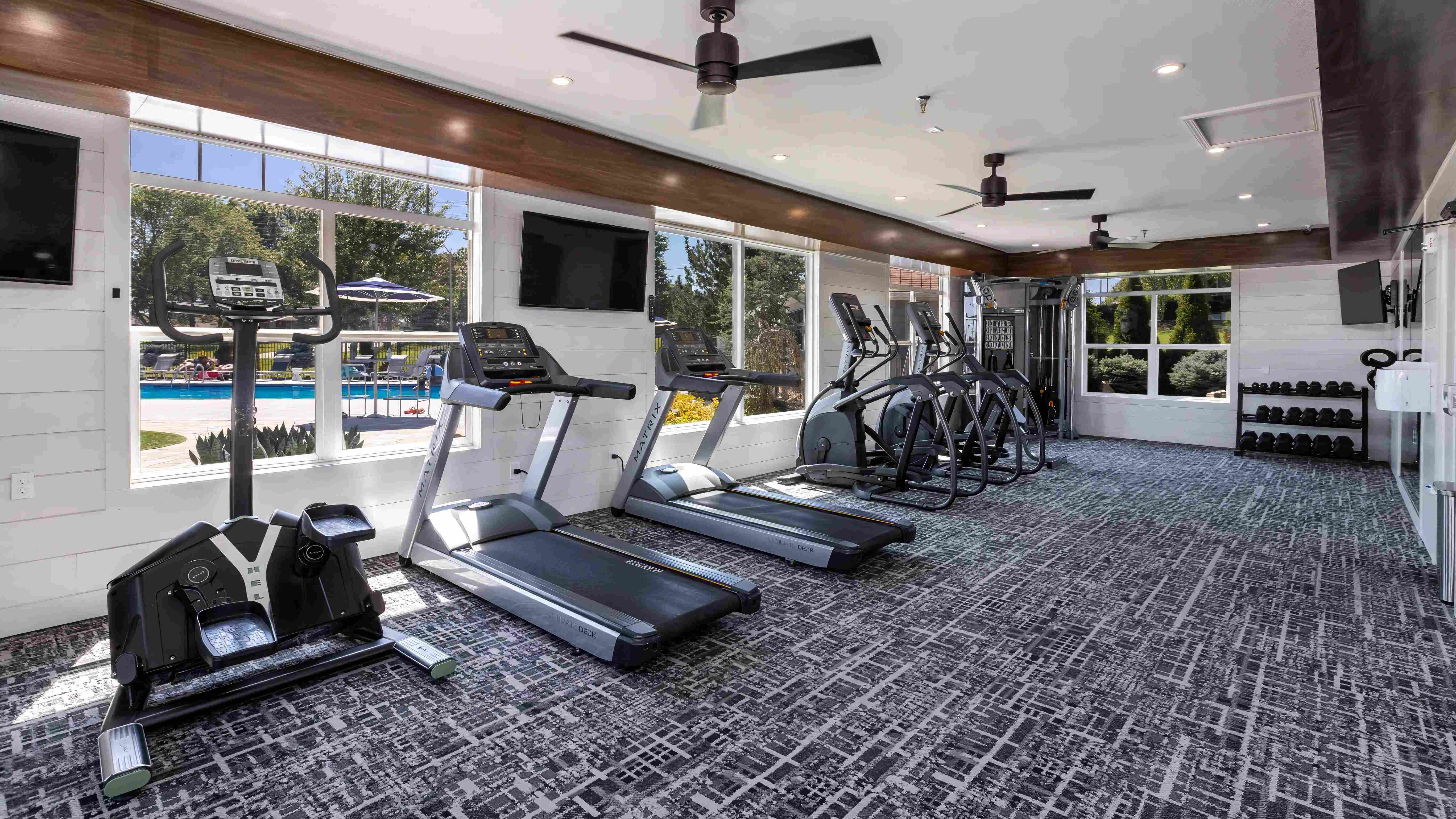 Our state-of-the-art fitness center offers a variety of equipment and a pool view to enhance your workout experience.
