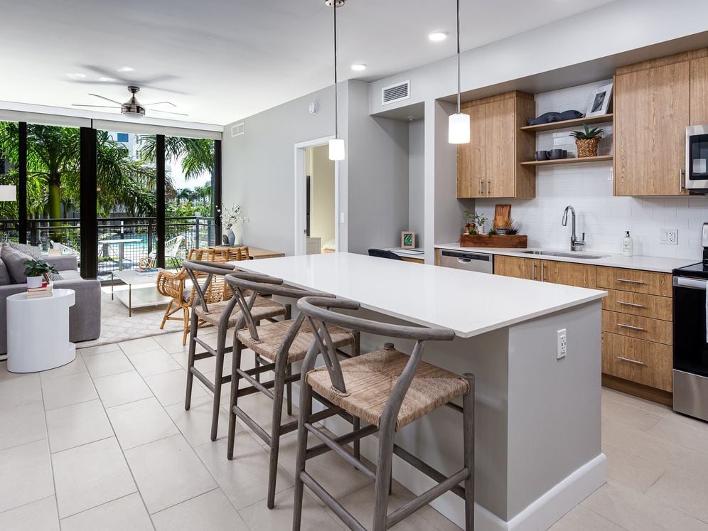 Open concept kitchen with quartz countertop, island, stainless steel appliances and tile backsplash