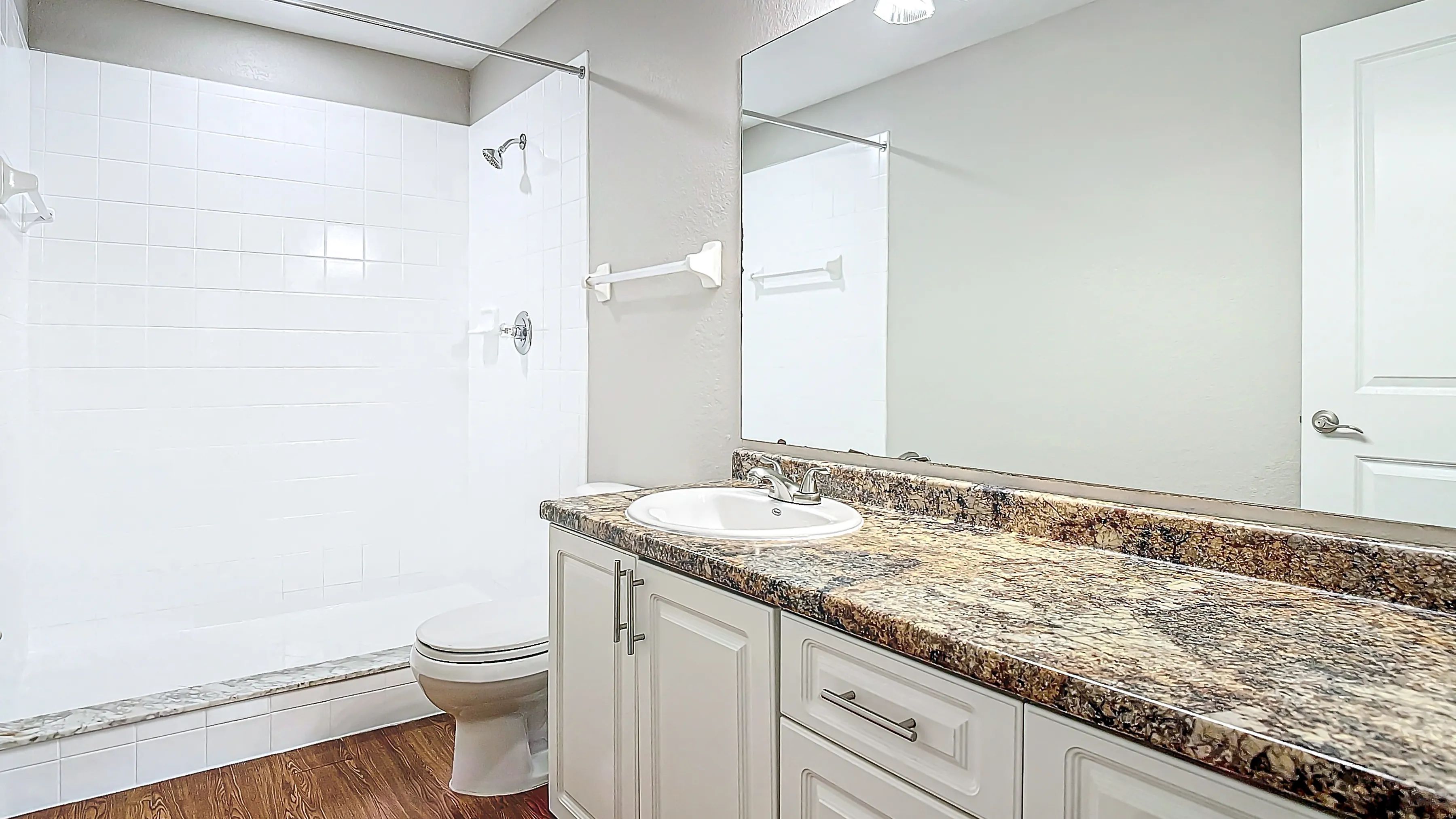 Master bathroom featuring a sleek design with granite-style countertops, a spacious vanity, and a modern walk-in shower, offering both style and comfort.
