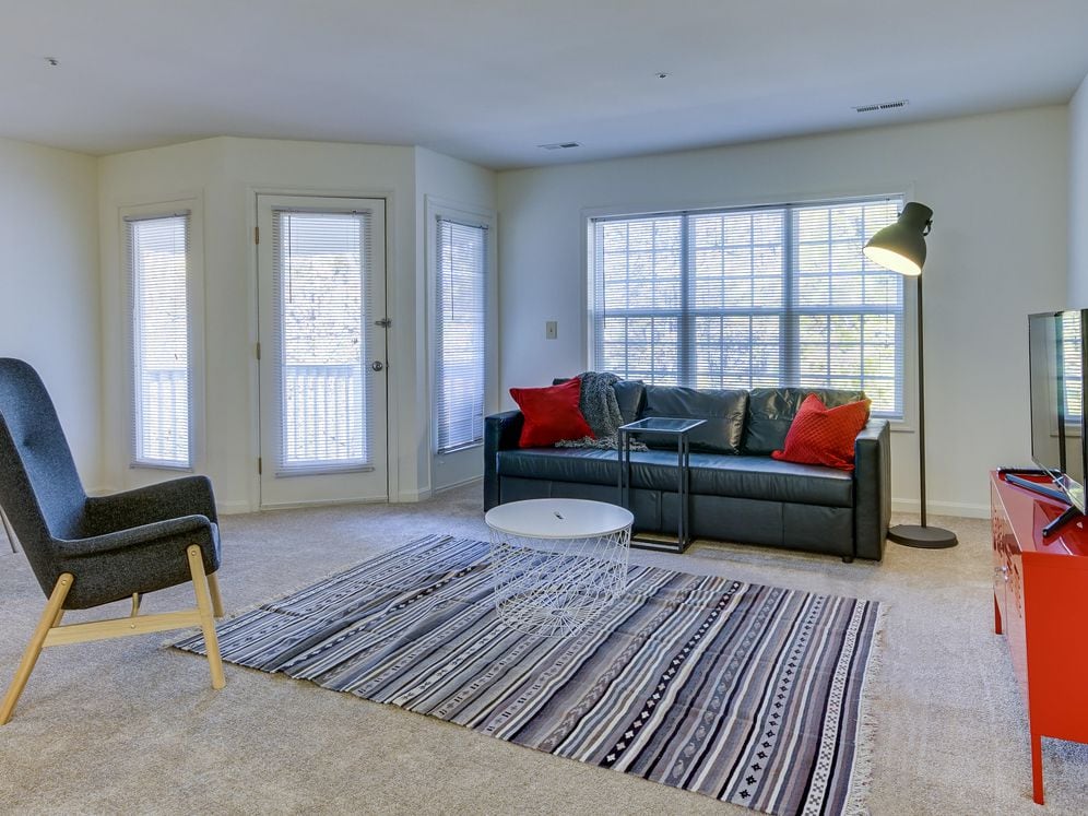 Carpeted living and dining area with balcony access